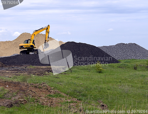 Image of  Yellow excavator working digging in sand quarry