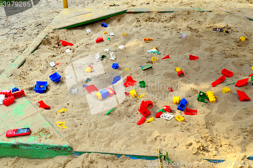 Image of Children's sandbox with toys scattered