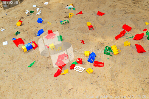 Image of Children's sandbox with toys scattered