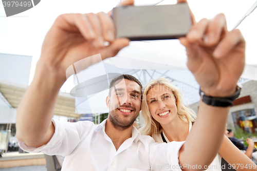 Image of couple taking selfie with smatphone at restaurant