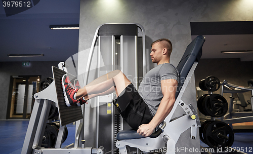 Image of man flexing leg muscles on gym machine