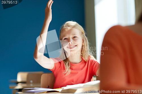 Image of happy student girl raising hand at school lesson