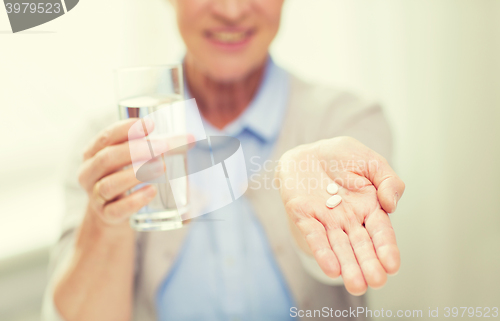 Image of close up of senior woman with water and pills