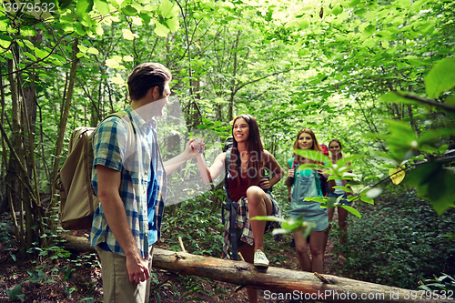 Image of group of smiling friends with backpacks hiking