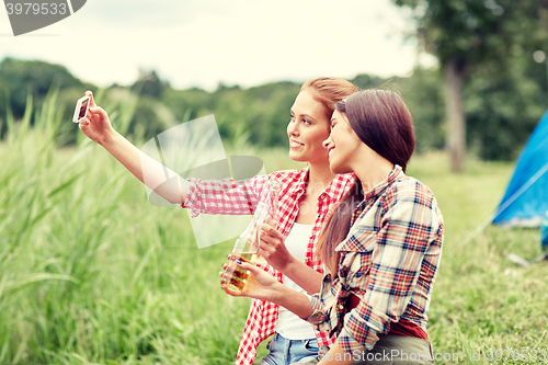 Image of happy women taking selfie by smartphone at camping
