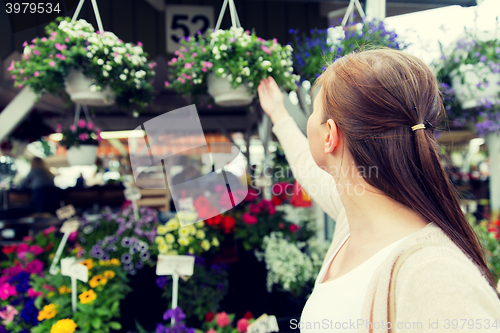 Image of woman choosing flowers at street market