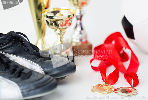 Image of close up of football boots, cups and medals