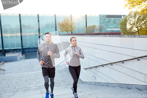 Image of happy couple running upstairs on city stairs