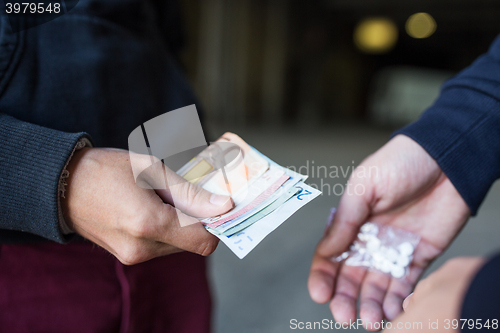 Image of close up of addict buying dose from drug dealer