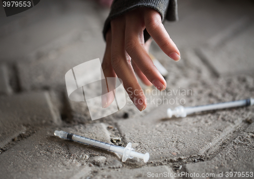 Image of close up of addict woman hands and drug syringes