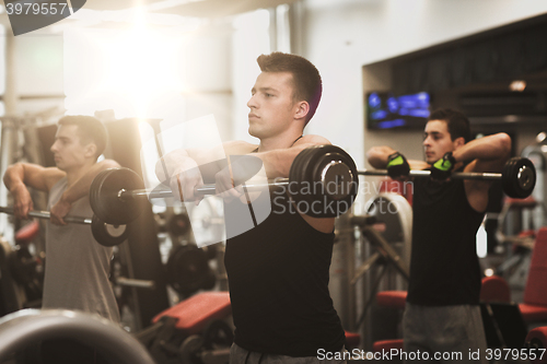 Image of group of men with barbells in gym