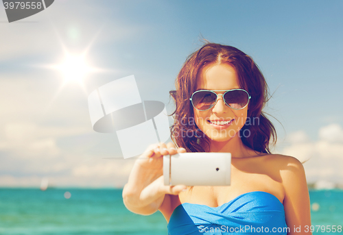 Image of woman in bikini with phone