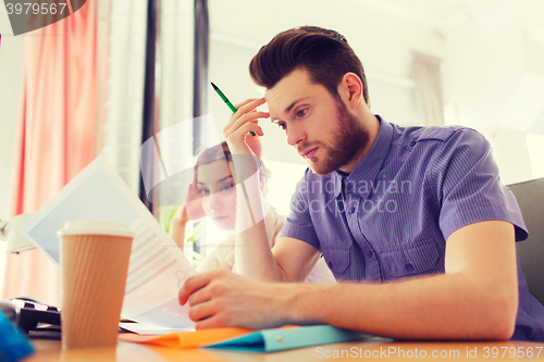 Image of creative team with computer and papers in office