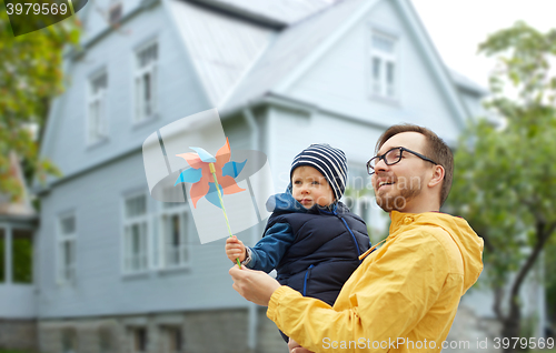 Image of happy father and son with pinwheel toy outdoors