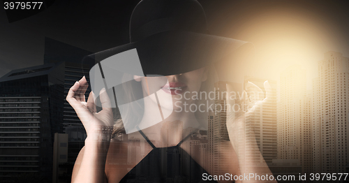 Image of beautiful woman in black hat over dark background