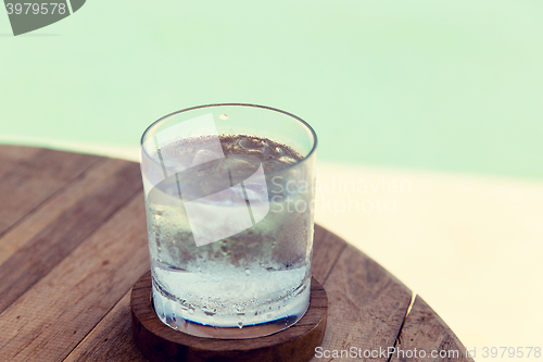 Image of glass of water with ice cubes on table at beach