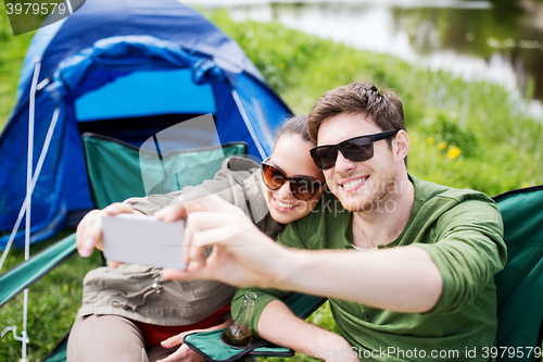 Image of couple of travelers taking selfie by smartphone