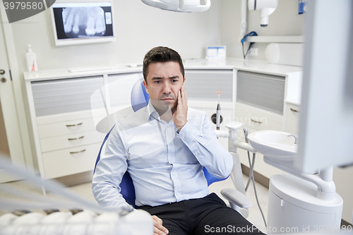 Image of man having toothache and sitting on dental chair