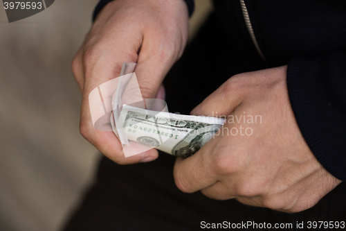 Image of close up of addict or drug dealer hands with money