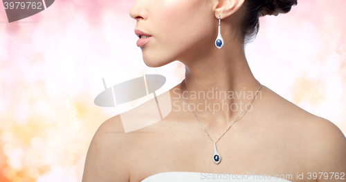 Image of close up of woman with earring and pendant