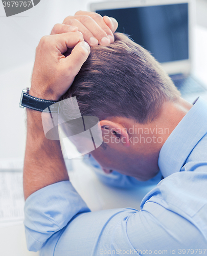 Image of stressed businessman at work