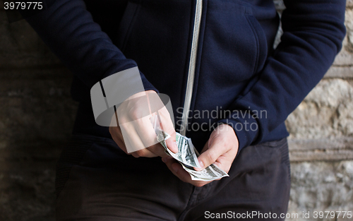 Image of close up of addict or drug dealer hands with money