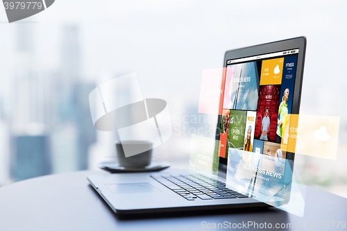 Image of close up of laptop and coffee cup on office table