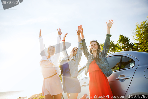 Image of happy teenage girls or women near car at seaside