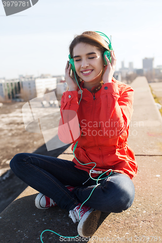 Image of happy young woman in headphones listening to music