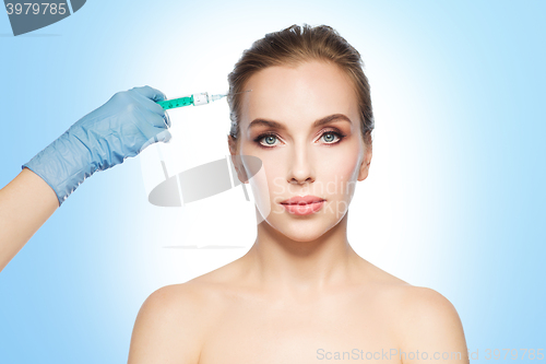 Image of woman face and hand with syringe making injection