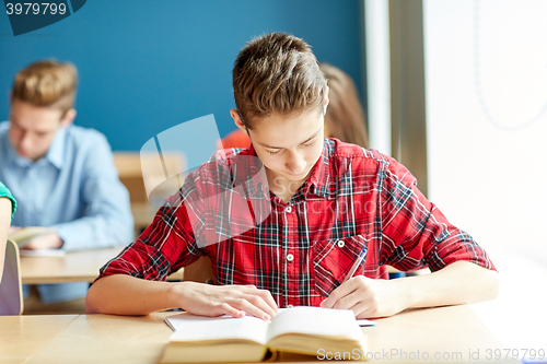 Image of group of students with books writing school test