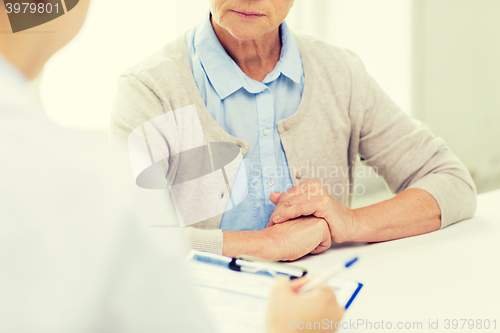 Image of close up of senior woman and doctor with clipboard