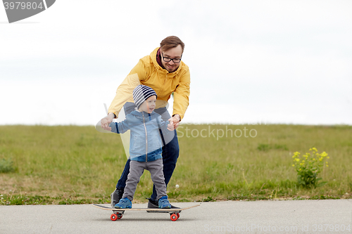 Image of happy father and little son on skateboard