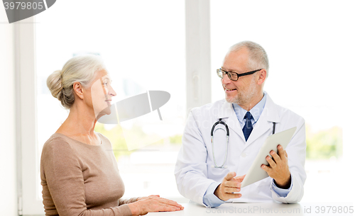 Image of smiling senior woman and doctor with tablet pc