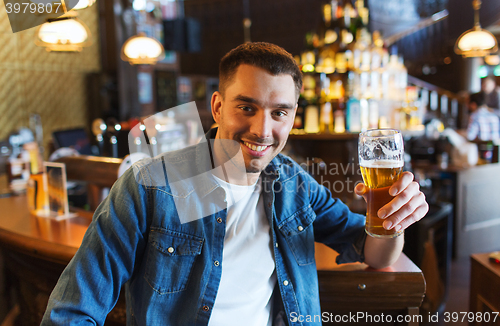 Image of happy man drinking beer at bar or pub