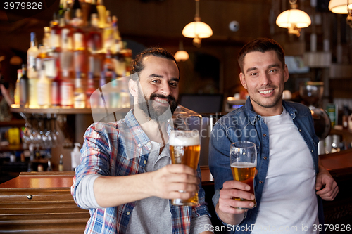 Image of happy male friends drinking beer at bar or pub