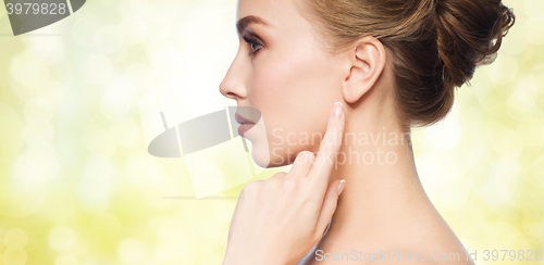 Image of beautiful woman pointing finger to her ear