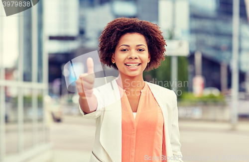 Image of happy young african american businesswoman in city