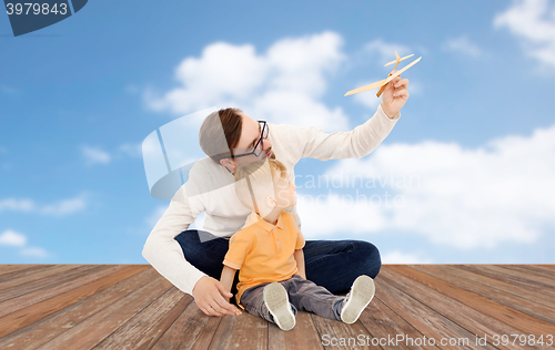 Image of father and little son playing with toy airplane