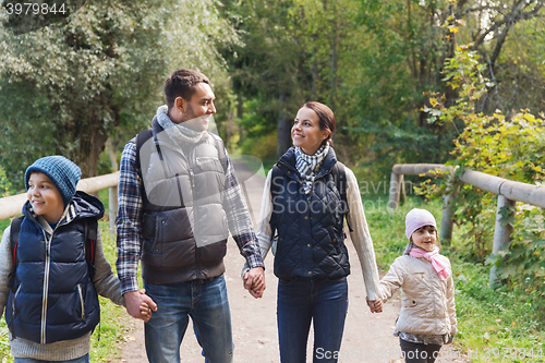 Image of happy family with backpacks hiking in woods