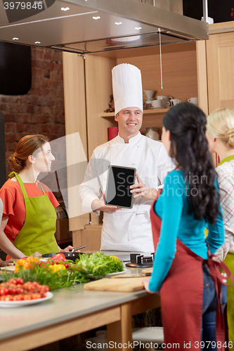 Image of happy women with chef and tablet pc in kitchen