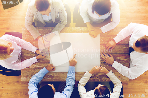 Image of close up of business team with paper at table