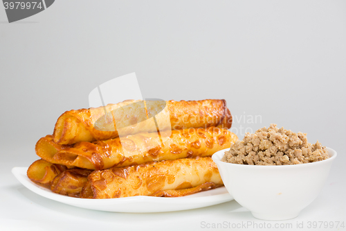 Image of pancakes with meat on white plate