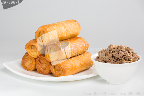 Image of pancakes with meat on white plate