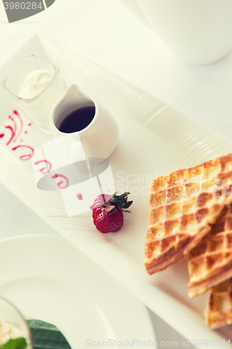 Image of close up of waffles on plate at breakfast table