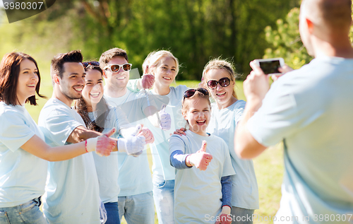 Image of group of volunteers taking picture by smartphone