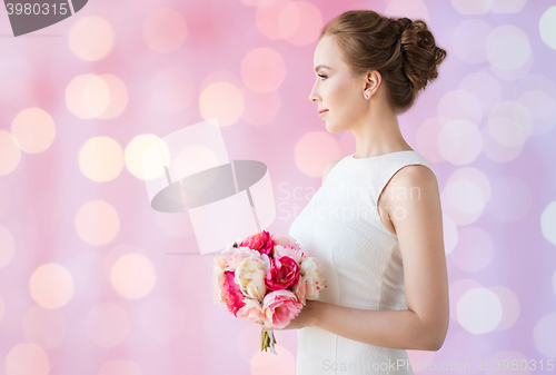 Image of bride or woman in white dress with flower bunch