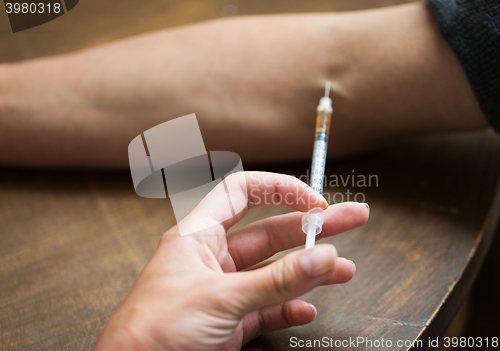 Image of close up of addict hand making drug injection