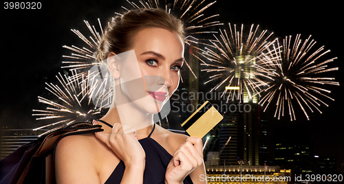 Image of woman with credit card and shopping bags in city