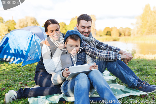Image of happy family with tablet pc and tent at camp site
